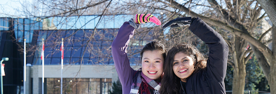 Two students outside of the international and graduate affairs building